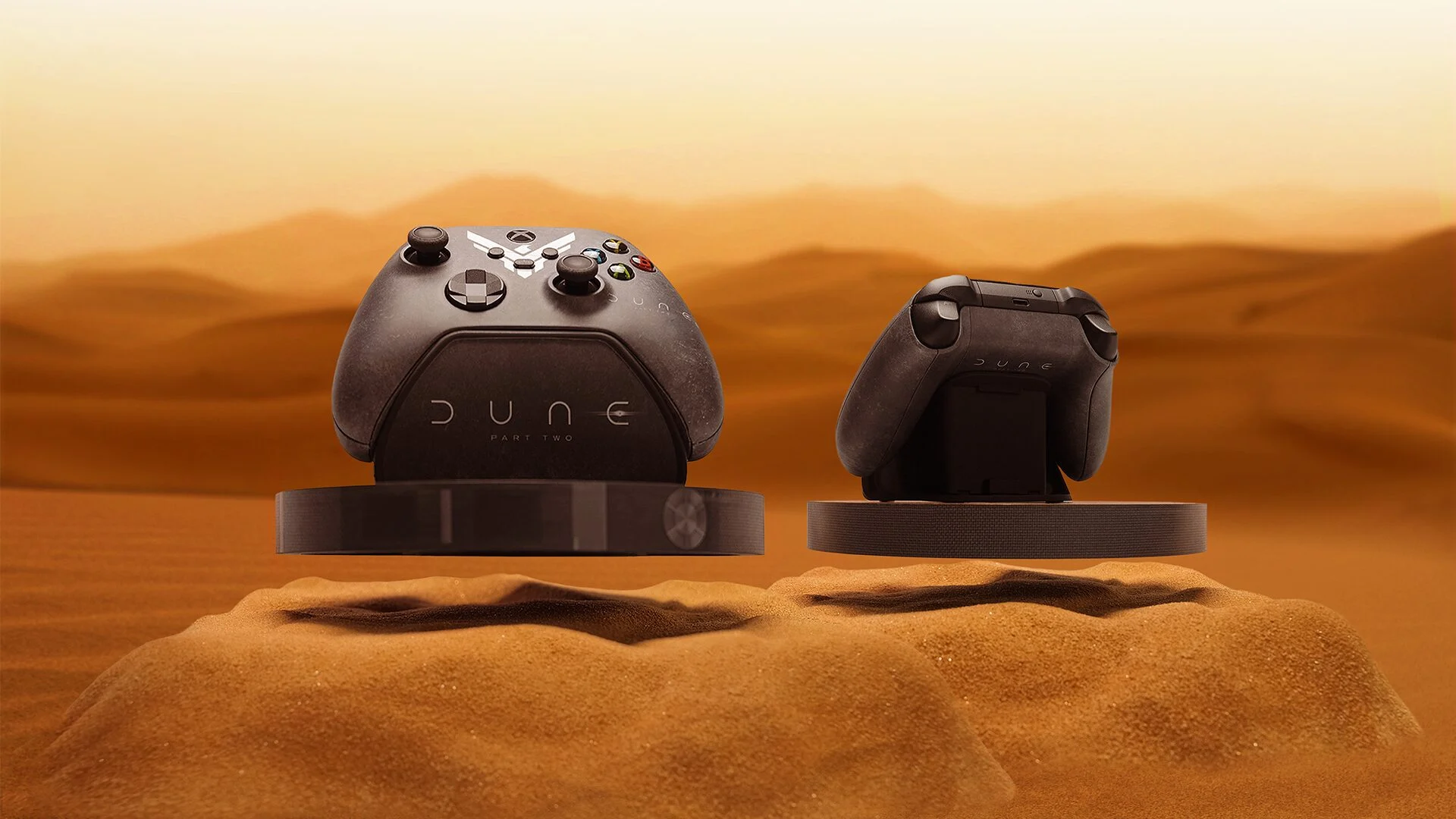 Two Dune: Part Two custom Xbox controllers floating above their bases over desert sand