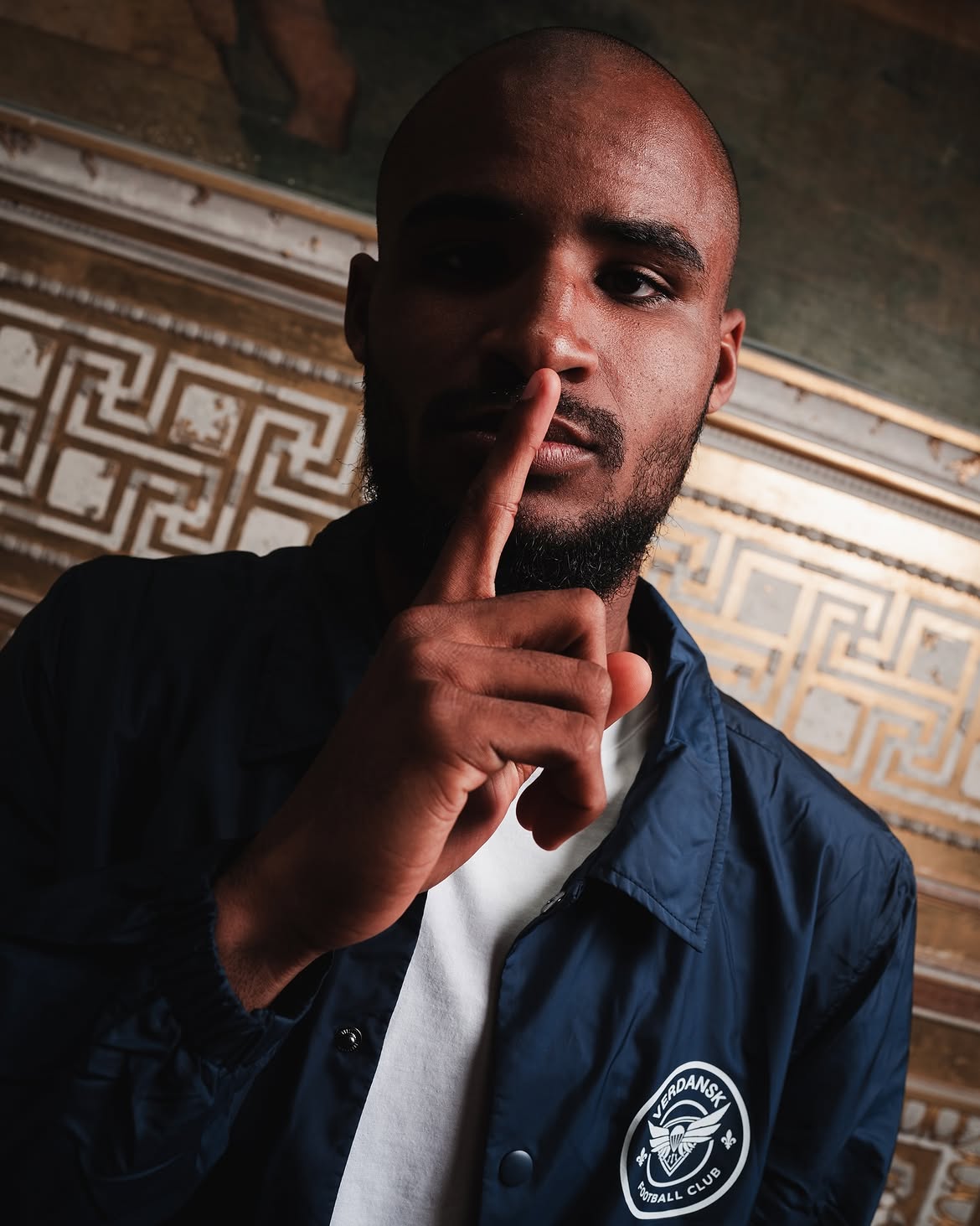 A player in an FC Verdansk jacket with a finger to his lips